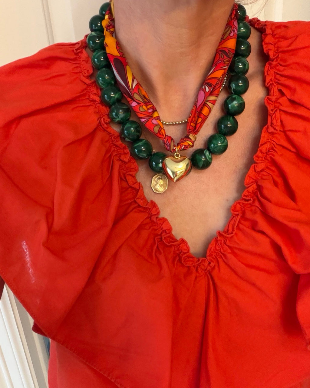 Woman wearing The Annie Kate silk scarf necklace with a red blouse