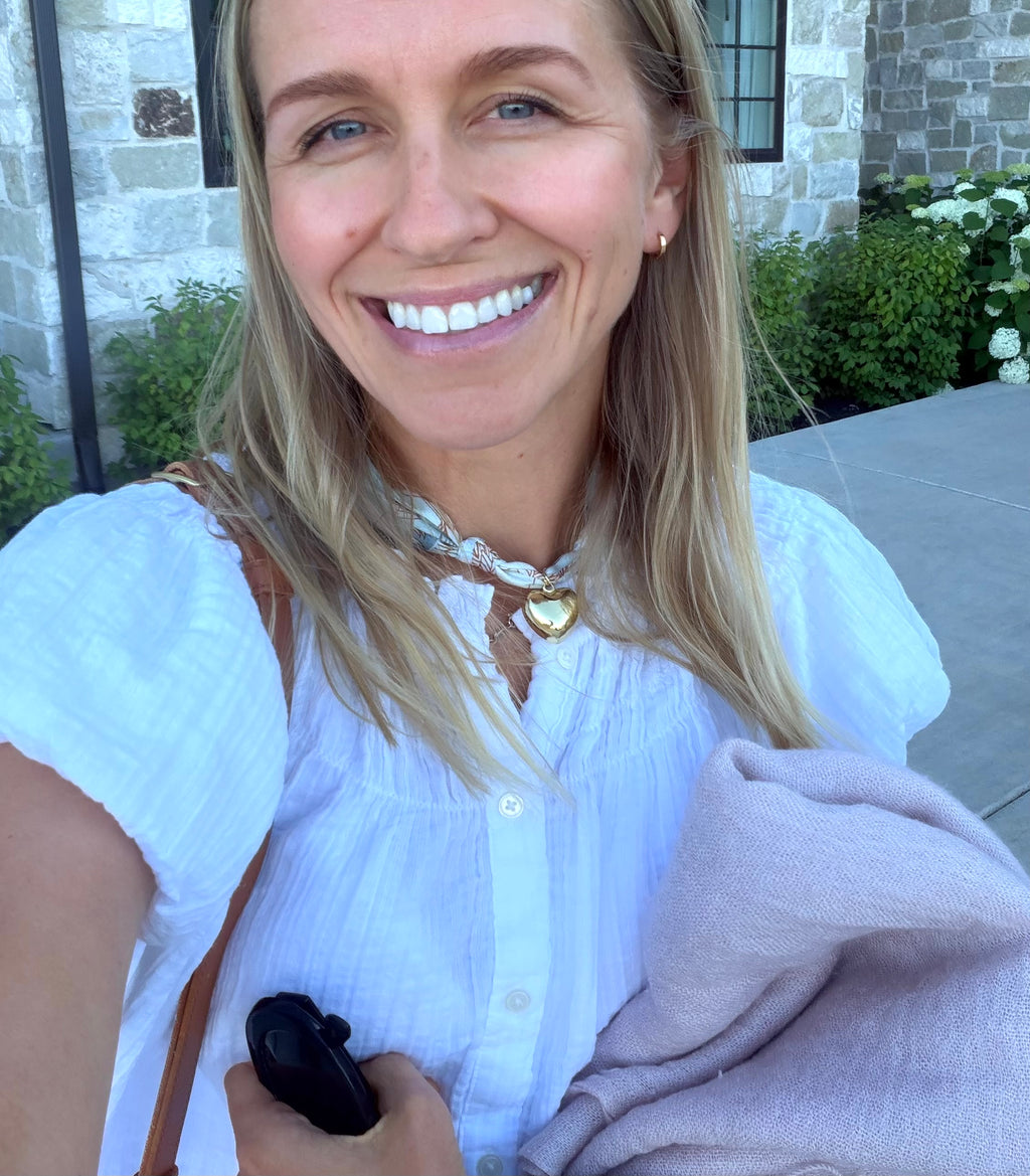 Woman wearing The Audrey silk-blend scarf necklace with a white button down blouse