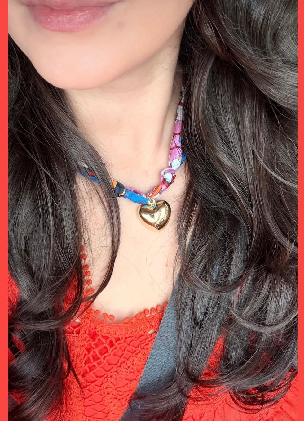 Woman wearing The Elizabeth silk scarf necklace with a red crochet top