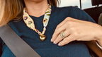 Woman wearing The Margaret silk scarf necklace with a dark blue t-shirt