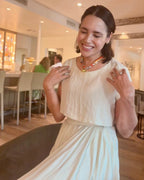 Woman wearing The Michelle silk scarf necklace with a white shirt and white skirt
