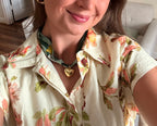 Woman wearing The Monica silk scarf necklace with a floral print button-down shirt