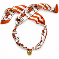 The Kreuger silk scarf necklace in burnt orange with gold heart pendant